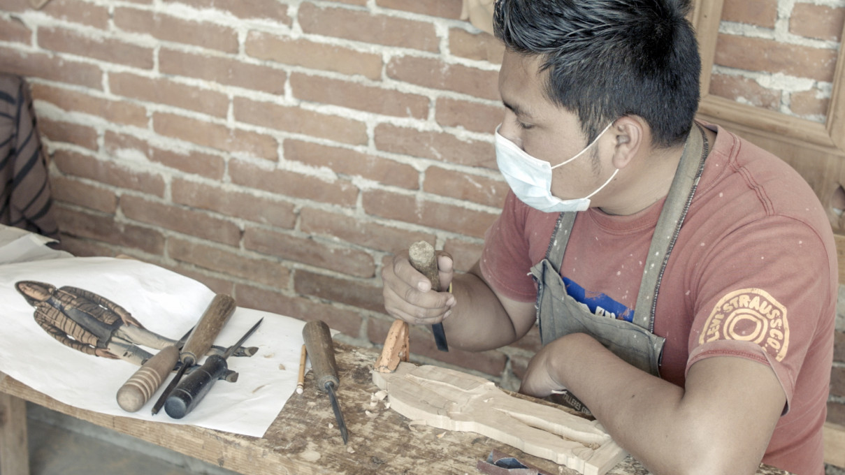 Erick, one of the artisans, carves his own portrait, a “metaportrait” from the film, transforming himself into one of the Men that Falls. Photo: Performing Pictures.